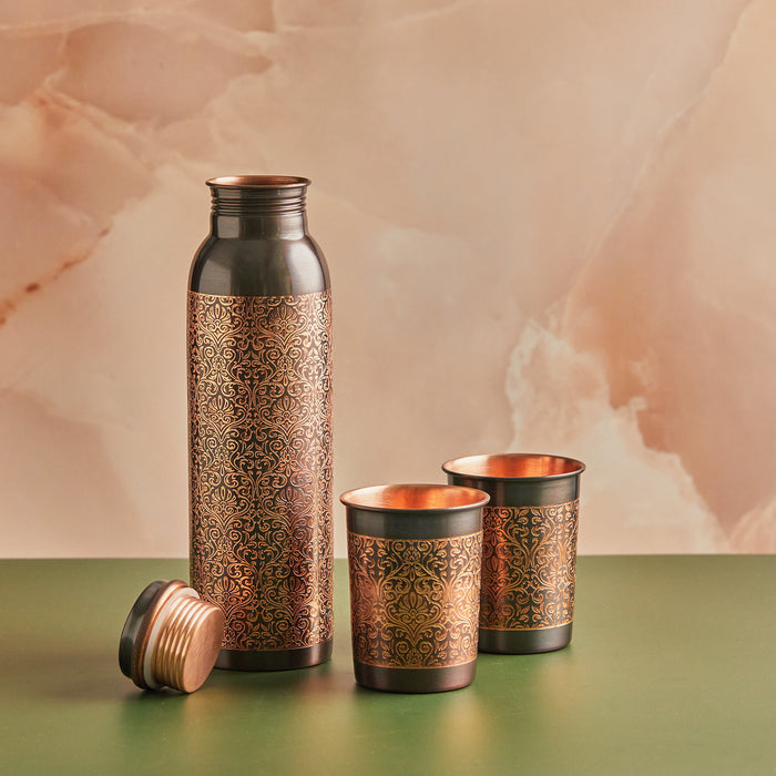 A set of pure copper drinkware which includes a water bottle and two glasses with black engraved style,