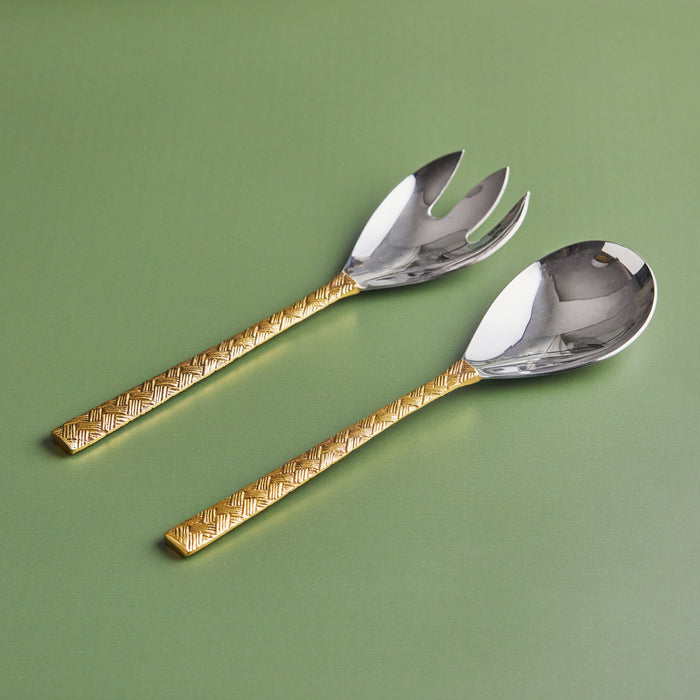 A stainless steel salad server with a brass handle, presented in a green box with a molded interior for each piece.